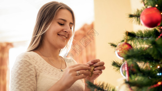 站在盛装圣诞树的美丽微笑女士肖像图片