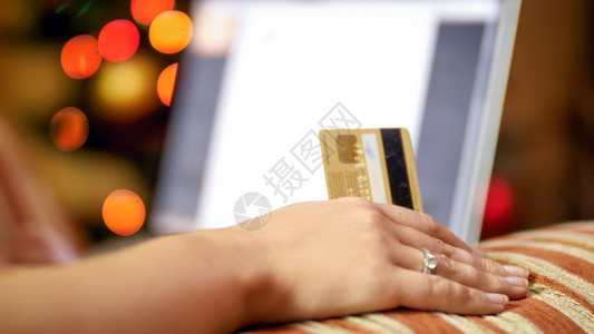 青年妇女持有信用卡和在笔记本电脑上浏览在线销售和商店的照片青年妇女持有信用卡和在笔记本电脑上浏览在线销售和商店的形象图片