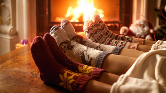 夜间在壁炉旁暖热的羊绒袜子父母与孩在夜间壁炉边暖热的羊绒袜子父母近照图片