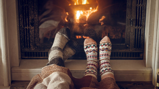 家庭穿着温暖的针织袜子躺在房壁炉旁家庭穿着温暖的针织袜子在房壁炉旁躺着的针织袜子图片
