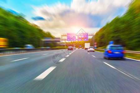 乘车驾驶高速公路日落时有交通和运动模糊效应图片