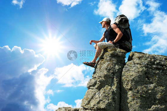 观光客坐在岩石上寻找边缘悬崖上的太阳图片