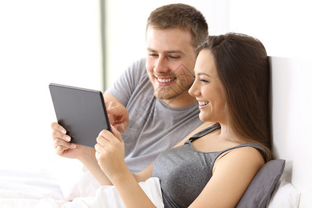 一对夫妇在公寓床上的平板在线观看媒体内容图片