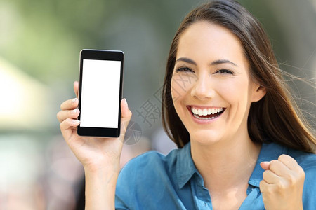 兴奋的女士在街上展示一个空白的电话屏幕图片