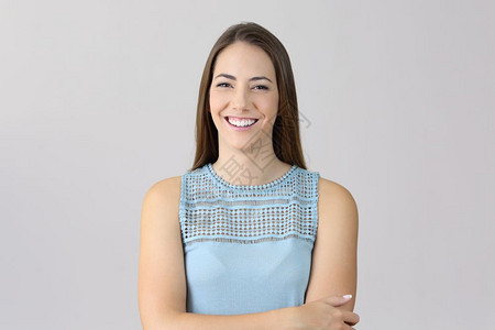一位快乐的女士肩膀折臂正面肖像看着你孤立在灰色背景上图片素材