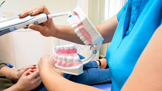 牙科医生教授病人如何使用电牙刷的近视图像牙科医生教授如何使用电牙刷的近照科医生教授病人如何使用电牙刷的近照图片