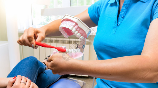女牙医的近视图像说明其病人对牙齿卫生的重要女牙医的近照片说明其病人对牙齿卫生的重要图片