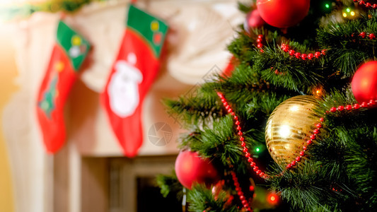 圣诞树上对壁炉的金黄色和彩灯光图片圣诞树上对壁炉灯光的金色和彩灯光图片图片