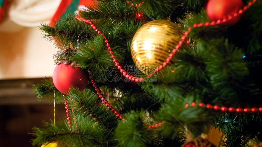 圣诞树的紧贴照片上面装饰着珠子和园地图片