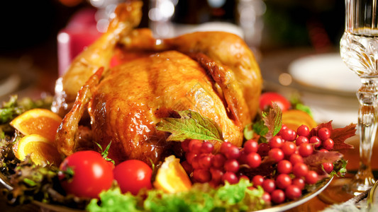 圣诞晚宴桌上大餐盘烤鸡的近照圣诞晚宴桌上大盘烤鸡的近照图片