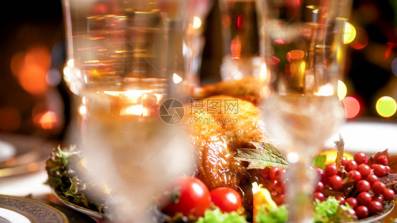 香槟杯对圣诞晚餐的烤鸡模糊画面香槟杯对圣诞节晚餐的烤鸡模糊画面图片