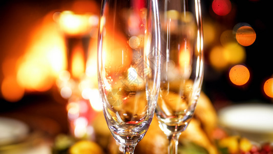 空香槟杯对着燃烧的壁炉和明亮圣诞树紧贴照片空香槟杯对着燃烧的壁炉和明亮圣诞树紧贴图像图片