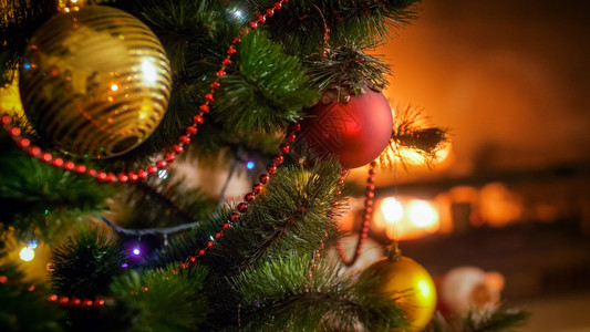 夜晚圣诞树上美丽的红色和金紧贴图像夜晚的圣诞树上有色彩多的光园夜晚圣诞树上美丽红色和金紧贴照片夜晚的圣诞树上有色彩多的光园图片