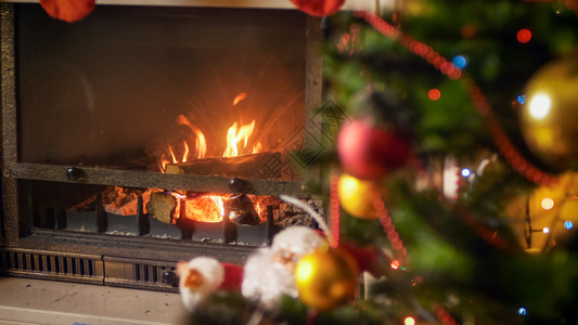 在圣诞节装饰的壁炉中烧焦原木在圣诞节装饰的壁炉中烧焦木图片