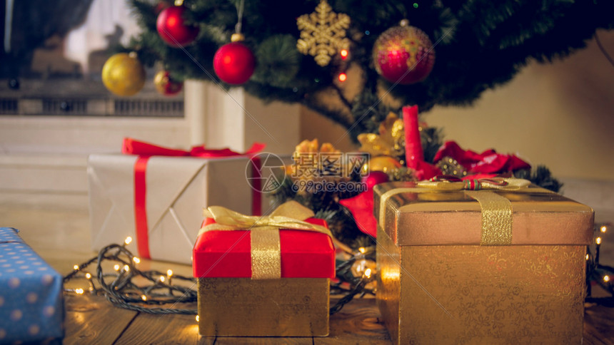 在客厅的圣诞树下面箱子里放着彩色礼品和圣诞树下面的礼物在客厅圣诞树下面箱子里放着彩色礼品和圣诞树下面的礼物图片