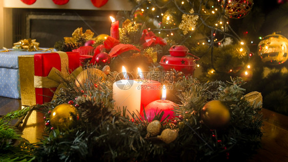 美丽的桌装饰着燃烧的蜡烛花圈和灯笼以庆祝圣诞节美丽的木桌装饰着燃烧的蜡烛花圈和灯笼以庆祝圣诞节图片