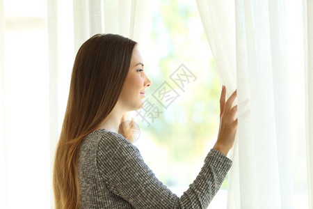 站在窗外看打开家客厅的窗帘侧面景象图片