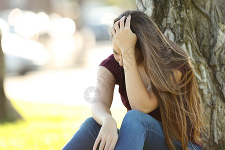 单身悲伤的女人坐在公园里哭泣图片素材