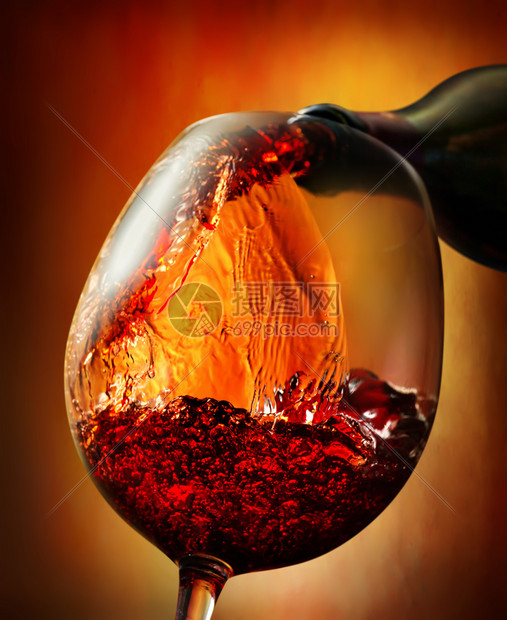 红酒倒入橙色背景的葡萄酒杯图片
