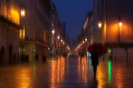 夜间照亮城市的雨天人们在下行走图片