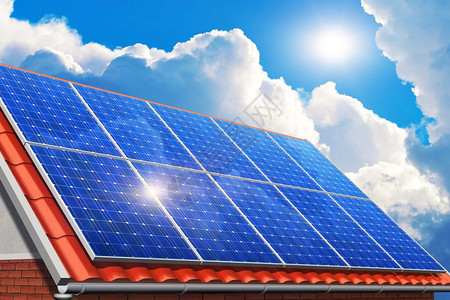 创意太阳能发电技术替代能源和环境保护生态商业概念红屋家或小的太阳能电池板组用太阳光和白云遮挡蓝天的屋顶在红家或小的顶上铺设砖状的图片