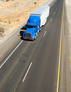 行驶在高速公路上的蓝色集装箱卡车图片