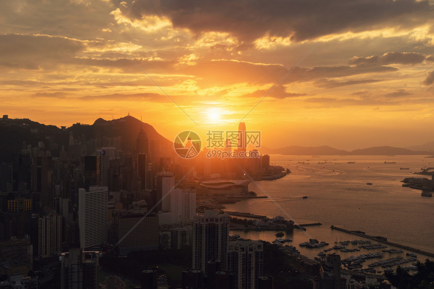 香港市区和维多利亚港的太阳下山智能城市的金融区高楼和天梯大日落时的空中景象图片