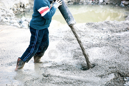 水泥或混凝土泵管加水泥或混凝土的建筑工人图片
