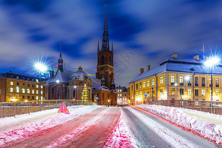 瑞典斯德哥尔摩老城GamlaStanRiddarholmen区雪街夜间冬季风景图片