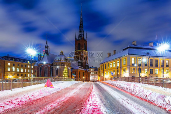 瑞典斯德哥尔摩老城GamlaStanRiddarholmen区雪街夜间冬季风景图片