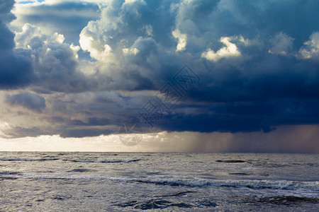 黎明的海景开始在大中暴雨阴暗的云天图片