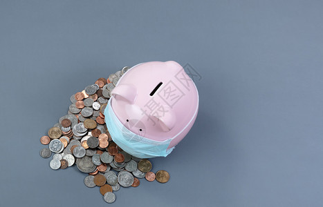 面戴外科具硬币的猪银行灰色桌上有硬币图片
