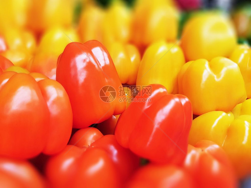 食品市场超或杂货店中含有选择焦点效应的红黄辣椒和甜堆积的宏观图片