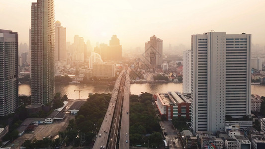 ChaoPhrayaRiver和TaksinBridge在金融区和摩天大楼的曲线空中观察城市曼谷泰国日落时区图片