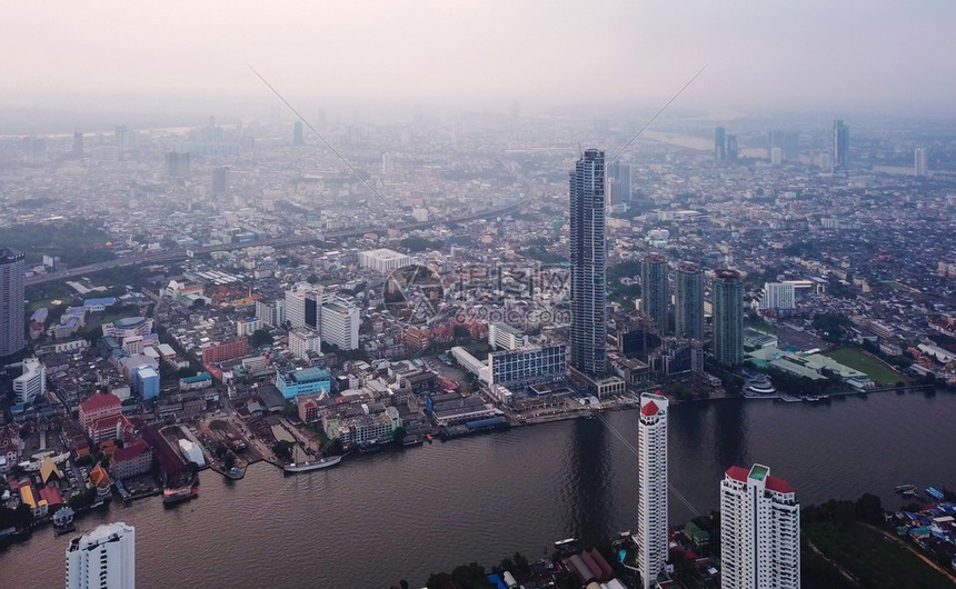 ChaoPhrayaRiver和TaksinBridge在金融区和摩天大楼的曲线空中观察城市曼谷泰国日落时区图片