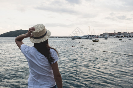 海边戴帽子的年轻女孩在望着地平线照片来自古代彩色Instagram风格海边的年轻女孩照片来自古代彩色Instagram风格图片