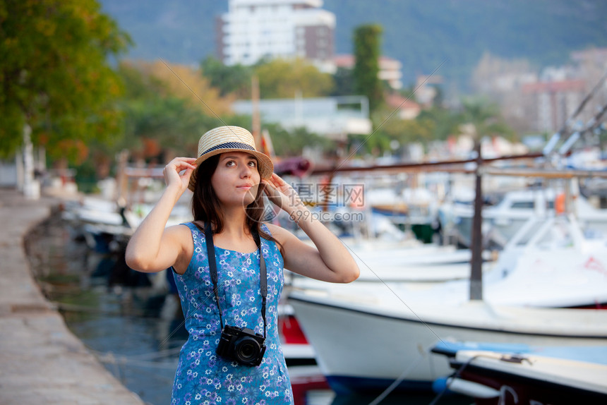 年轻有吸引力的快乐旅行女孩在旧地中海城市带着相机走在旧地中海城市
