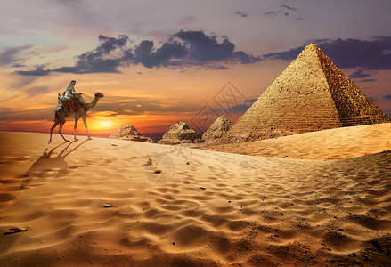 沙漠中金字塔附近骆驼上的贝都因人图片