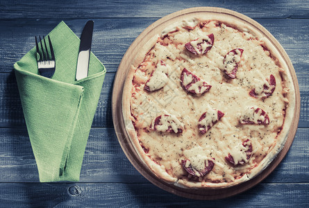 木制桌上的辣椒尼披萨图片