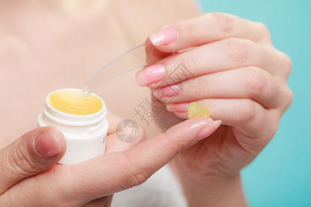 美人化妆品概念女手将用塑料装置施黄色面霜女手将施用黄色奶油图片
