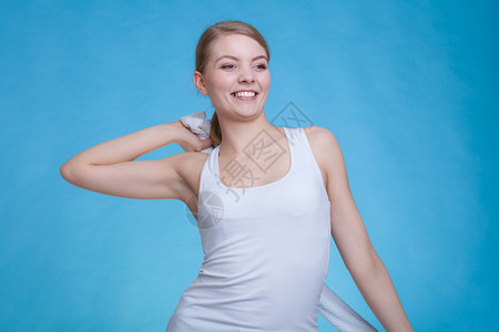 微笑的女人背着毛巾摄影棚拍蓝背景图片