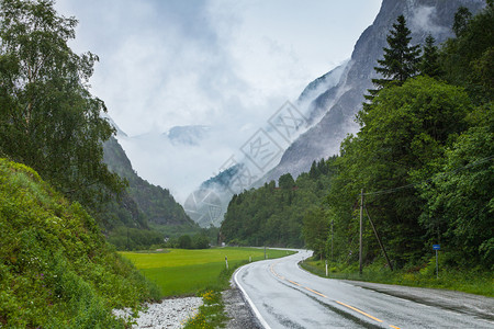 穿过挪威山的通路雾雨日美丽的绿色夏季风景旅行和游图片