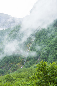 山上瀑布雾雨日美丽的绿色夏季风景旅行和游山地雾日挪威的瀑布图片