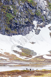 欧洲ScandynavavaviaNorwegian雪山附近路面和查看Norwegian雪山的平面桌和长椅图片