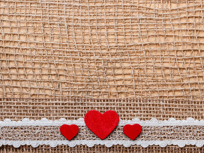 红色木制装饰式心胸带放在抽象布上背景带有复制空间图片