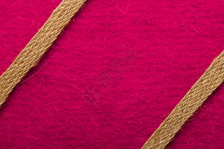 由粉红色纺织品背景上粗糙的绳形成边框或架背景图片