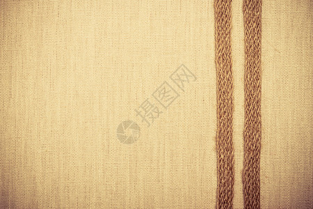 天然亚麻布背景的明织纺品材料上黄麻袋带图片