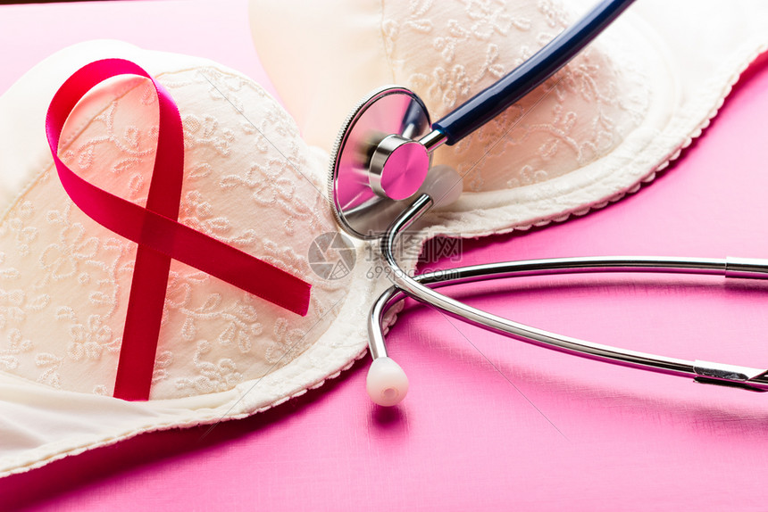保健医药和乳腺癌认识概念对女胸罩和粉色背景进行丝带听诊器的闭合图片