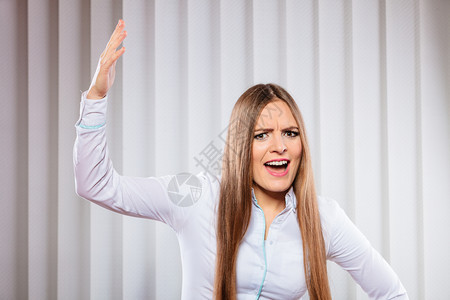 在工作上处理压力和情绪沮丧的女尖叫感到愤怒和手举起来张开嘴正式穿戴服装的妇女在办公室中愤怒的年轻女公共汽车大喊叫图片