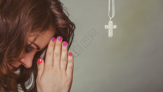 女人用十字项链向祈祷强烈的信仰女人用十字项链向祈祷图片